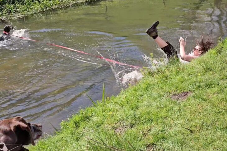 Moment woman is dragged into river while playing with her excited dog in hilarious video footage